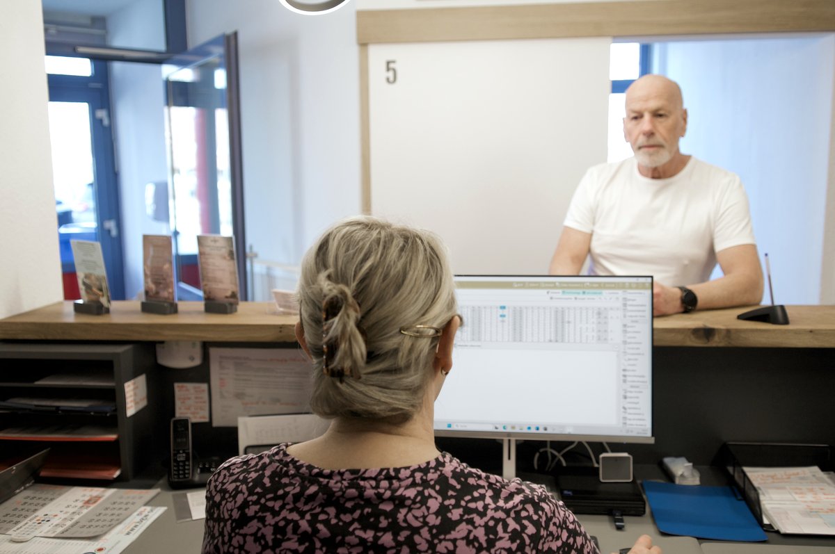 Freundlicher Empfang: Patient wird am Anmeldetresen begrüßt
